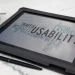 A tablet sitting on top of a table next to a cup of coffee displaying different aspects of accessibility testing