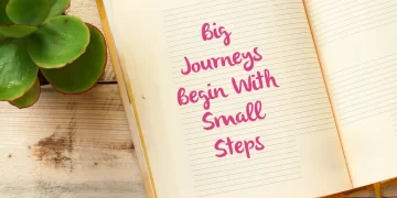 Open notebook with inspirational quote: Big Journeys Begin With Small Steps, symbolizing the start of a developer's journey.