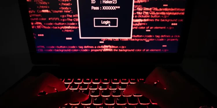 Anonymous user entering credentials on a secure login page with code in the background