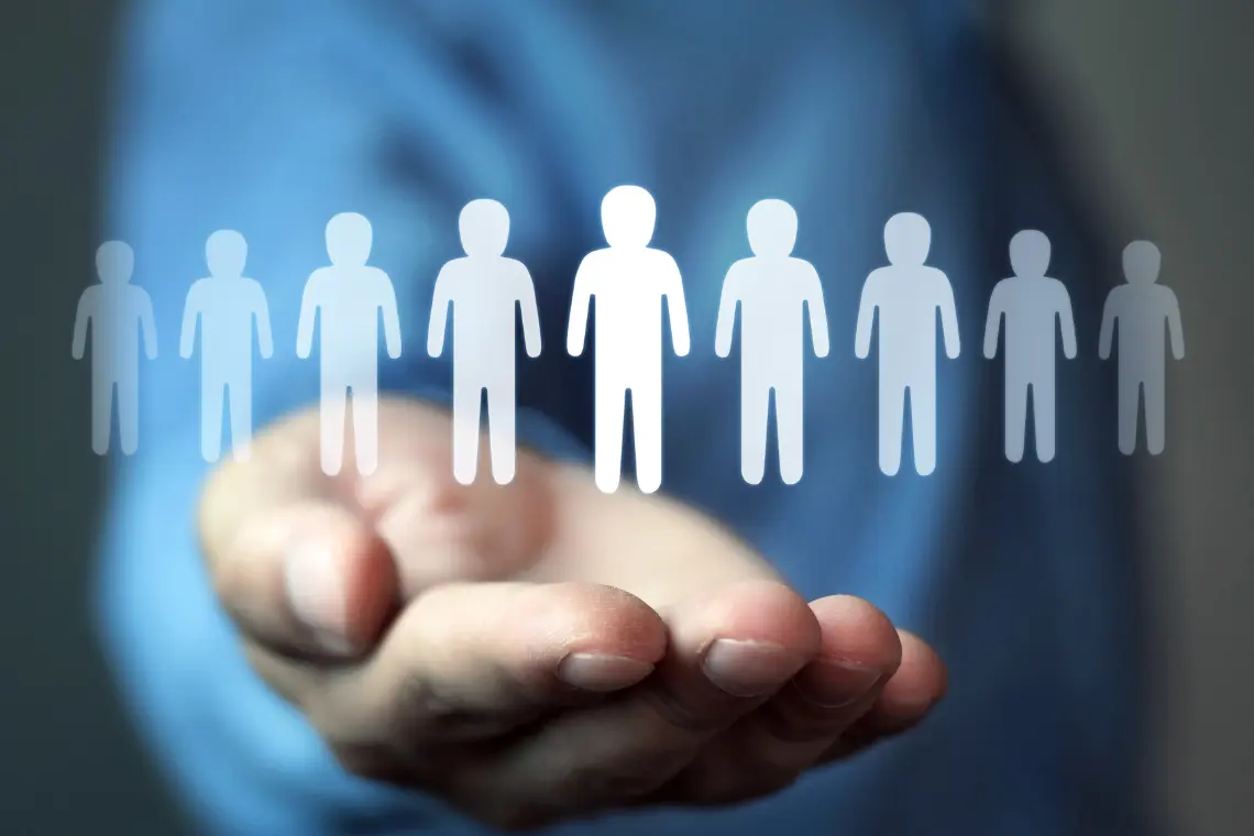 Hand holding icons representing people