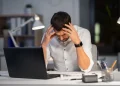 A frustrated blogger sitting at a desk, struggling with SEO and monetization challenges—the bitter truth of blogging.