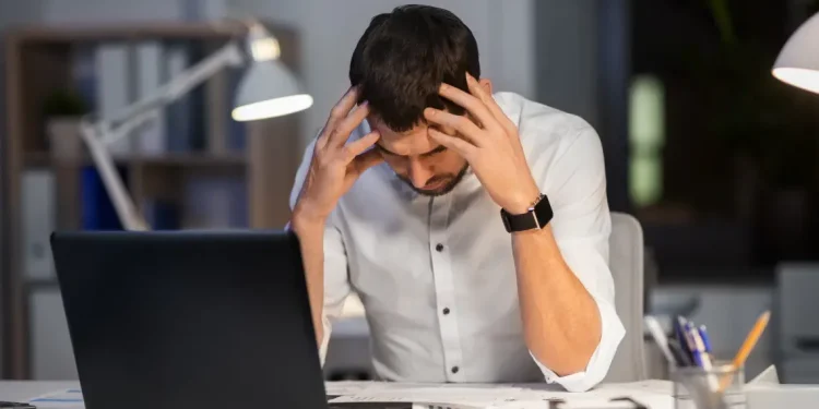 A frustrated blogger sitting at a desk, struggling with SEO and monetization challenges—the bitter truth of blogging.