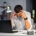 A frustrated blogger sitting at a desk, struggling with SEO and monetization challenges—the bitter truth of blogging.