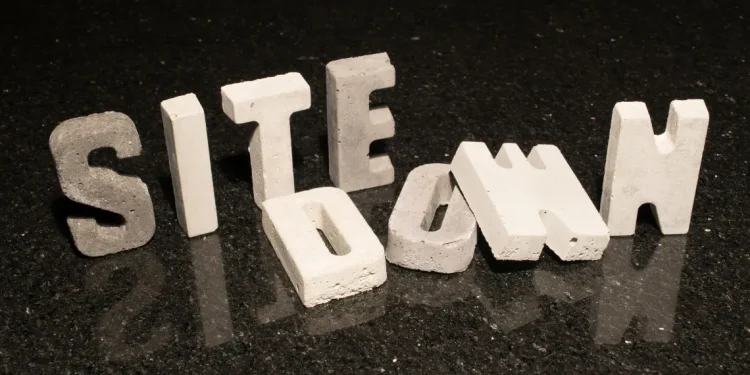 Concrete block letters spelling 'SITE DOWN' representing website downtime.