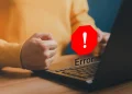 Frustrated user facing a website error on a laptop, indicating Elementor troubleshooting issues.