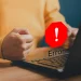 Frustrated user facing a website error on a laptop, indicating Elementor troubleshooting issues.